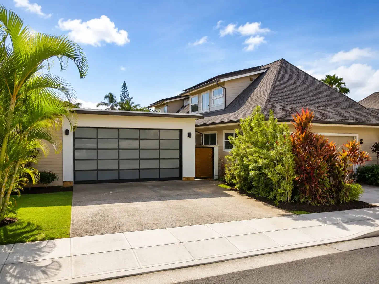 Modern Oahu garage door on a landscaped Kahala-area home.